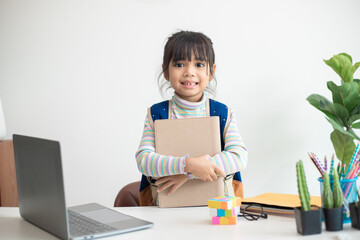 Asian student girl wearing school backpack and holding exercise book. Portrait of happy Asian young girl.Back to school