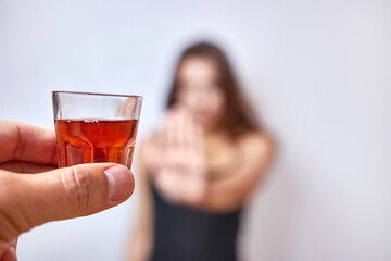 The girl is offered a glass of alcohol, but she categorically refuses. The concept of giving up alcohol.
