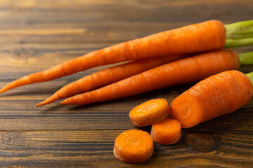 Fresh carrots on brown texture background. Ingredient for salad.Vegetarian organic vegetables.Healthy food.Copy space.Place for text