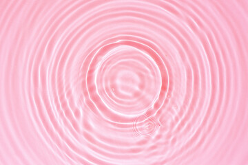 Abstract cosmetic background, pink water texture with round ripples, close up
