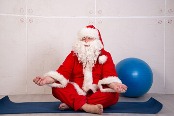 Funny fat Santa Claus goes in for sports at home.	