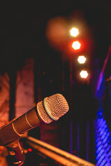 Colorful musical performance: close-up view of microphone on stage with vibrant colorful lights in...