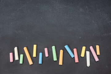 Variation of colored chalk sticks on blackboard. Copy space. Back to school - Powered by Adobe