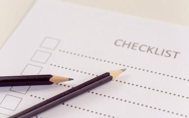 Checklist concept - checklist form paper and pencil on white table