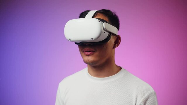 Korean man using virtual reality glasses, playing video games, Asian guy wearing new generation gaming headset for entertainment, amusement park, future technology concept.