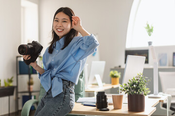 Young Korean Female Photographer Holding Photocamera Standing At Home