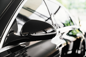 side view mirror on a black luxury car. 