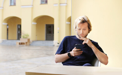 Lifestyle portrait of a young man using a smart phone outdoors