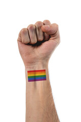 Beautiful and stylized hand and arm of caucasian person with fist up and a big tattoo of LGBTQ flag of pride over 100% white background