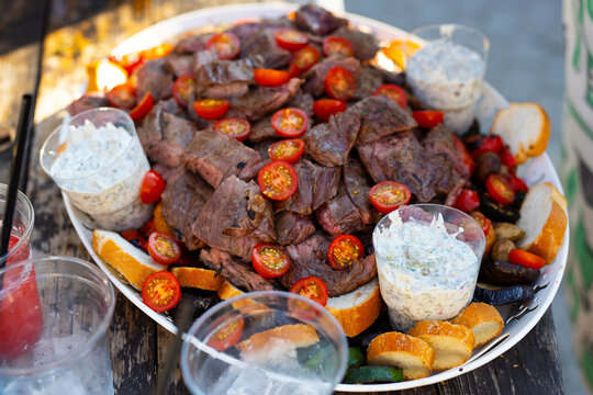 A Large Plate Of Meat On A Picnic Table