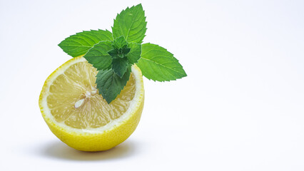half lemon and fresh green mint leaves isolated on white background