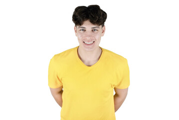 Teenage boy smiling happily on a white background in a yellow t-shirt, the boy has beautiful healthy white teeth and has pimples on his face, medical concept