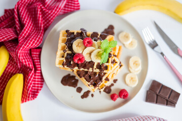 delicious belgian breakfast waffles with strawberries and raspberries and chocolate and banana