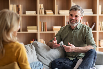 Fototapeta premium Communication In Marriage. Happy Middle Aged Couple Chatting At Home