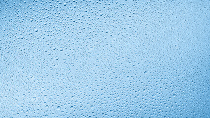 Medium size water drops on the wet glass surface on blue background | Background for skin care moisturizing products