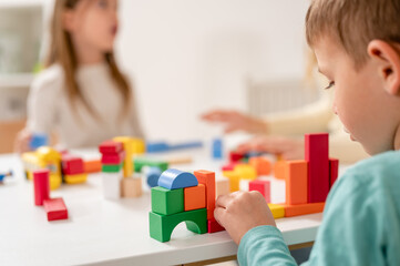 Kindergarten children playing with colorful building blocks. Healthy learning environment. Learning through play. - obrazy, fototapety, plakaty