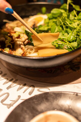 bamboo shoots in a bowl of ramen noodle soup being eaten with a pair of chopsticks 