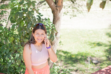 Young woman playing sports outdoors, sharing her day with her cell phone.
