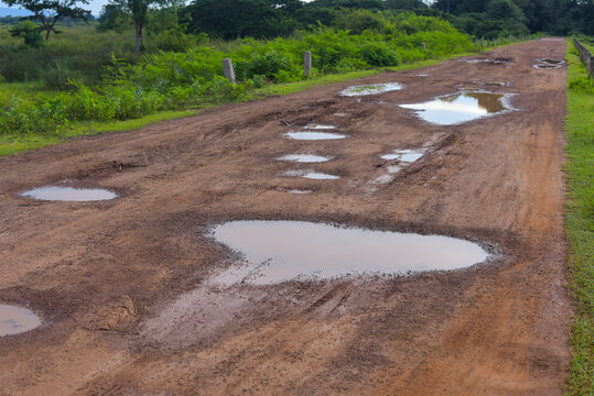 Rural damaged road with muds and holes