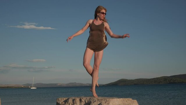 woman dancer jumping on the rock, assemble temps leve