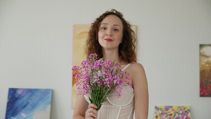 4K. The bride with a bouquet of flowers looks into the camera