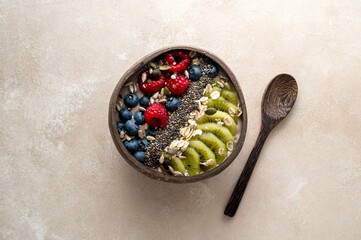 Smoothie bowl with fresh berries, kiwi, oats, chia seeds. Breakfast healthy meal, bright background