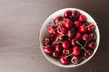 Sweet cherries with drops of water in the white bowl. Cherry organic berries harvest - healthy eating and food concept