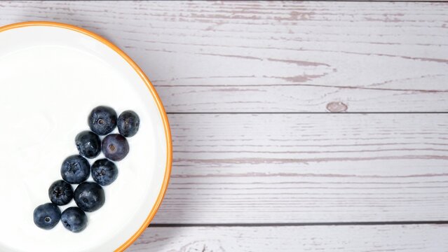 Yoghurt bowl garnished with blueberries as part of the picture