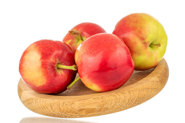 Several ripe sweet red apples with a wooden saucer, close-up isolated on a white background.