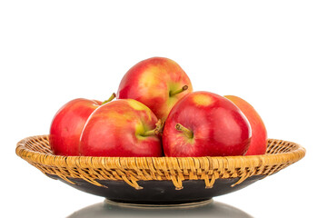 Several ripe sweet red apples on a clay dish, close-up, isolated on a white background