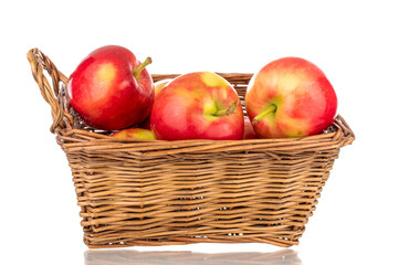 Fototapeta na wymiar Several ripe sweet red apples in a basket, close-up, isolated on a white background.
