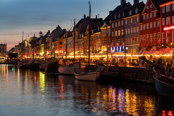 Obraz premium Nyhavn canal with sunset view It is a sightseeing and entertainment district with old ships and colorful houses from the 17th and early 18th centuries. 20 July 2022 Copenhagen, Denmark 