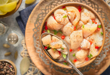 Arabic cuisine; Egyptian traditional boneless trotters soup. served with fresh lemon and black pepper. Top view with close up.