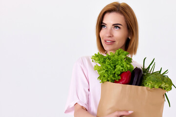 caucasian woman hold paper bag with vegetables