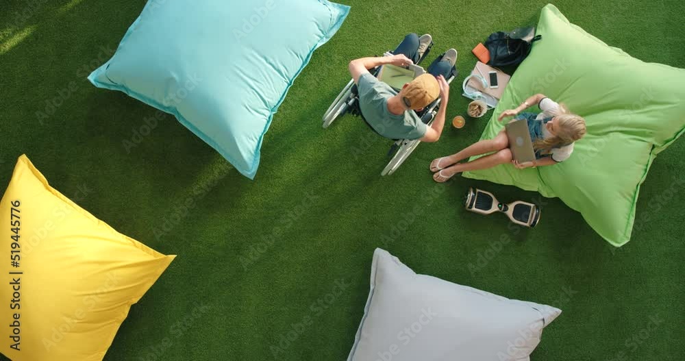 Aufkleber FA17-03-R-41. A disabled business man handing documents to a coworker in a modern outdoor workspace. Overhead view of diverse colleagues working outside in a futuristic and inclusive startup company.