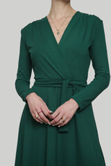 Serie of studio photos of young female model in emerald green wrap dress. 