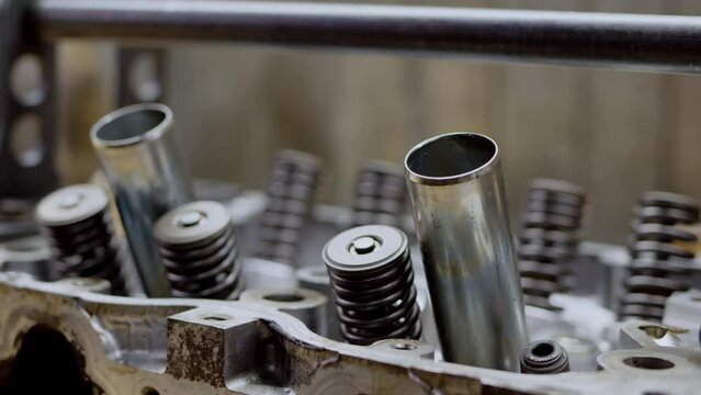 close up view of disassembled sixteen-valve four-cylinder engine. day at car service, engine overhaul, close view of valve stem seals. Beautiful clean silver car engine.