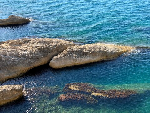Rocks in the sea. Scenic rocky coast of Mediterranean sea. Clear shiny turquoise water.