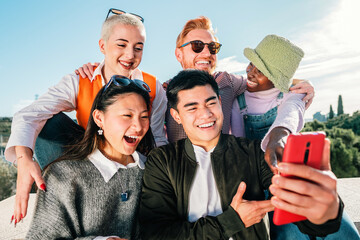 Obraz premium Group of friends watching a video in smartphone smiling and having fun together outdoor.
