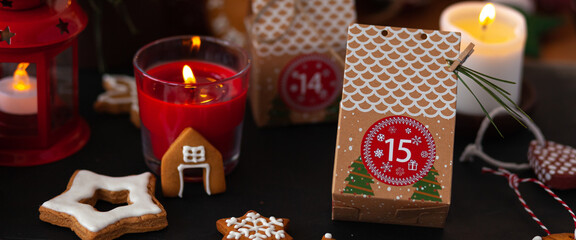 Preparing original Advent holiday calendar for Christmas or New year as countdown to Christmas Eve for kids. Zero waste paper package, homemade gingerbread cookies. Cozy atmosphere. Banner