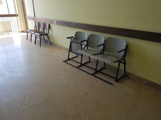 Empty wooden chairs in the waiting room of the hospital corridor