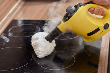 Cleaning of induction cooker with steam cleaner.