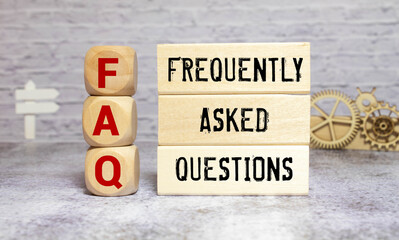 FAQ or frequently asked question concept. Wooden blocks with text on desk.