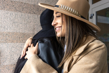 Happy close female friends greeting each other in building exterior