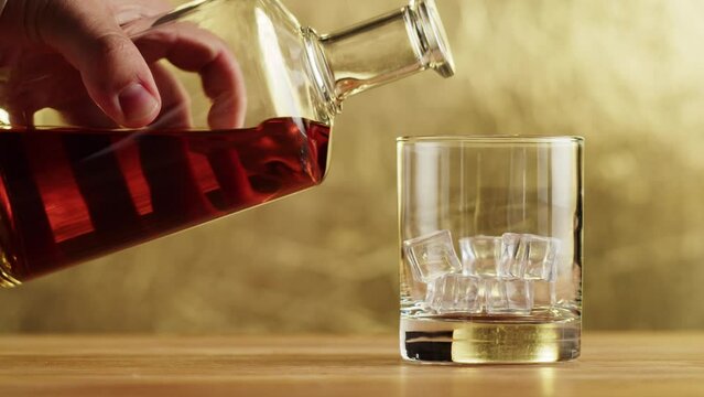 Brandy or whiskey close-up. Luxury cognac. Alcohol amber drink with ice, drinking rum, liqour beverage in glass.
