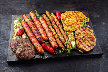 Traditional Grillplatte mit Bratwurst, Hamburger und Steaks zubereitet für eine Sommer Grillparty...