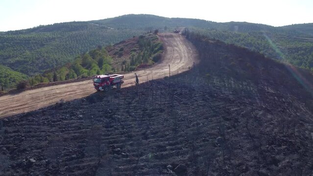 Izmir, Turkey - July 23, 2022: Aerial footage view aftermath the forest fire with a firetruck at Derya site Seferihisar Doganbey Turkey