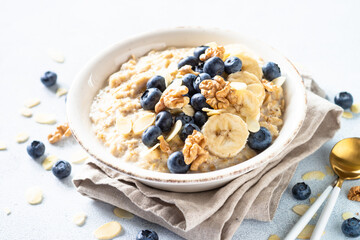 Oatmeal porrige in craft bowl at white background. Healthy breakfast.