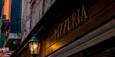 Old rustic signboard with the word pizzeria
