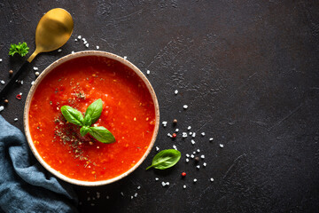 Tomato soup on black background. Traditional vegan dish. Top view with copy space.